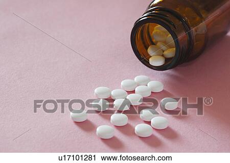Stock Image - Pills spilling out of bottle. Fotosearch