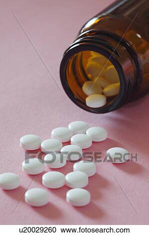 Stock Image - Pills spilling out of bottle. Fotosearch