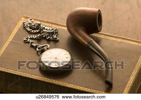 Stock Photograph - Pipe and pocket watch on book. Fotosearch