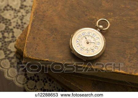Stock Image - Pocket watch on books. Fotosearch