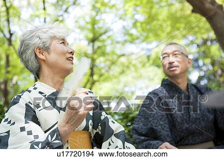 Picture - Senior couple wearing Yukata sitting on bench. Fotosearch