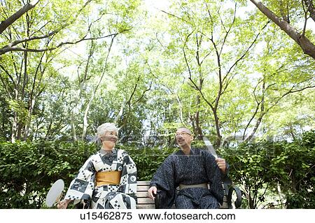 Stock Photography - Senior couple wearing Yukata sitting on bench. Fotosearch