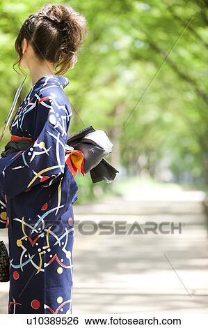 Side view of a young woman wearing Yukata View Large Photo Image Stock Photograph - Side view of a young woman wearing Yukata. Fotosearch