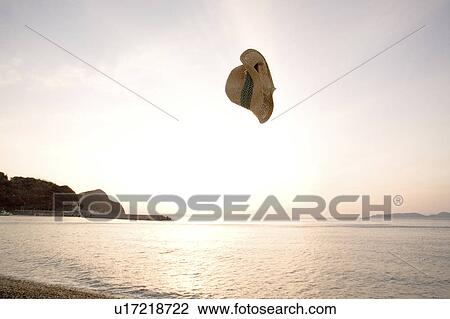 Stock Image - Straw Hat in the air. Fotosearch