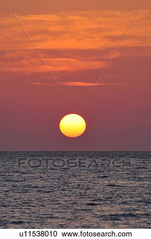 Stock Image - Sun Setting Over Sea. Fotosearch