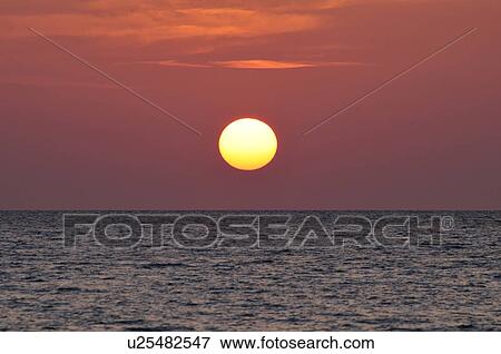 Stock Photo - Sun Setting Over Sea. Fotosearch