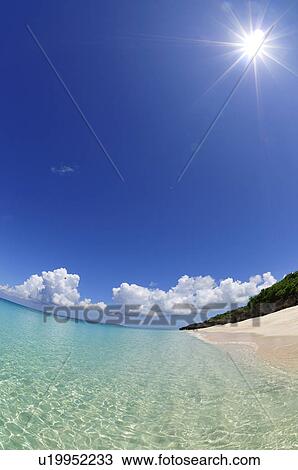 Stock Image - Sun Shining Over Beach. Fotosearch