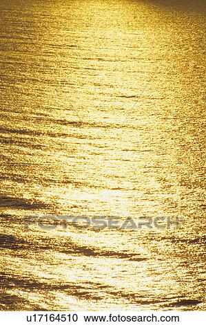 Stock Image - Sunlight reflecting on water. Fotosearch