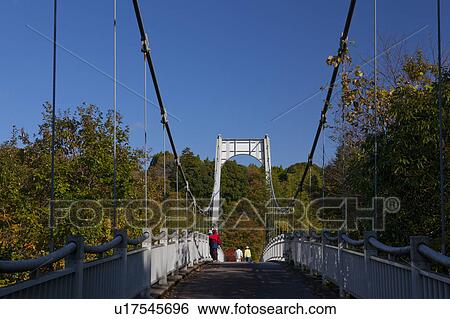 Stock Photograph - Suspension Bridge at Kameyama Lake. Fotosearch