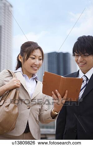 Stock Photograph - Two Businesspeople Looking at Diary. Fotosearch