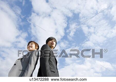 Stock Photo - Two Businesspeople Standing Back To Back. Fotosearch
