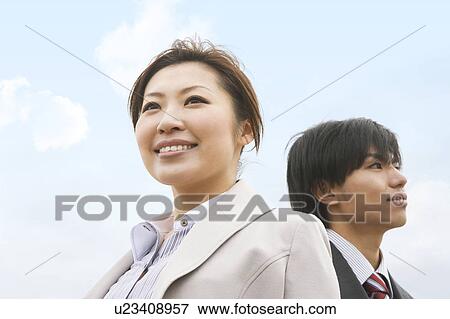 Stock Photo - Two Businesspeople Standing Below Blue Sky. Fotosearch