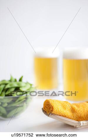 Stock Image - Wet towel, edamame and beer. Fotosearch