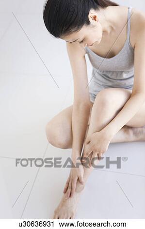 Stock Image - Woman sitting on floor. Fotosearch