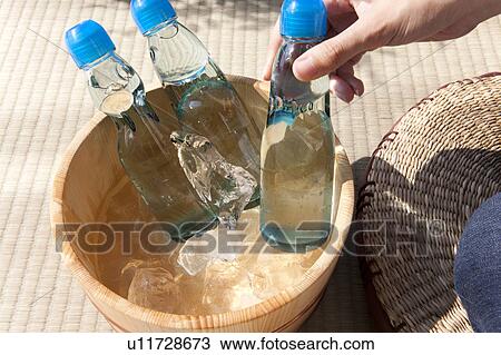 Woman taking out a bottle of soda from a bucket View Large Photo Image Stock Image - Woman taking out a bottle of soda from a bucket. Fotosearch