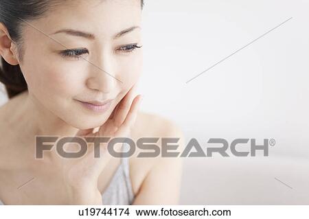 Picture - Woman touching her cheek. Fotosearch