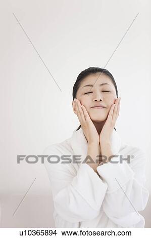 Woman touching her cheeks View Large Photo Image Picture - Woman touching her cheeks. Fotosearch