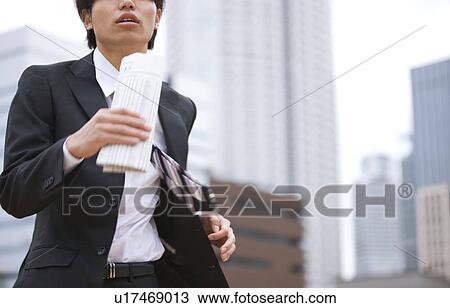 Young businessman holding newspaper and running View Large Photo Image Stock Image - Young businessman holding newspaper and running. Fotosearch