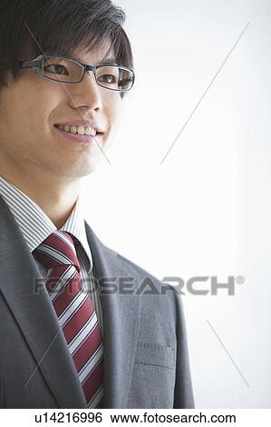 Young businessman wearing glasses and smiling View Large Photo Image Stock Photograph - Young businessman wearing glasses and smiling. Fotosearch