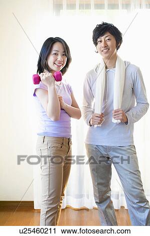 Stock Image - Young Couple Exercising with Dumbbells. Fotosearch