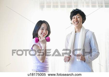 Stock Photography - Young Couple Exercising with Dumbbells. Fotosearch