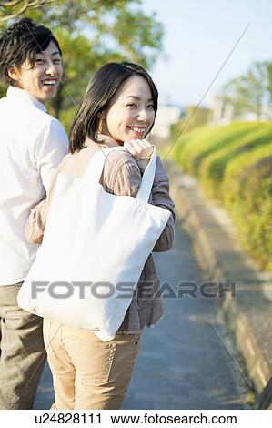 Young Couple Walking and Looking Back at Camera View Large Photo Image Stock Image - Young Couple Walking and Looking Back at Camera. Fotosearch