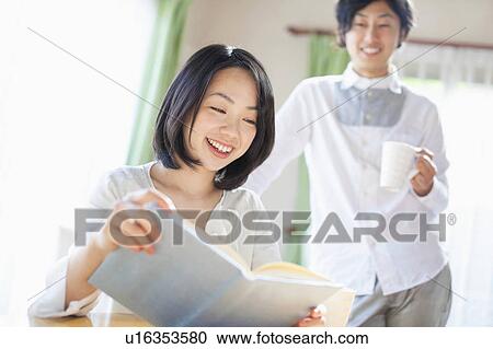 Young Woman Reading Book, Boyfriend in the Background View Large Photo Image Stock Image - Young Woman Reading Book, Boyfriend in the Background. Fotosearch