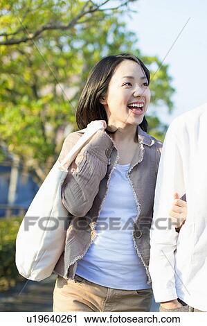 Stock Image - Young Woman Walking with Boyfriend. Fotosearch