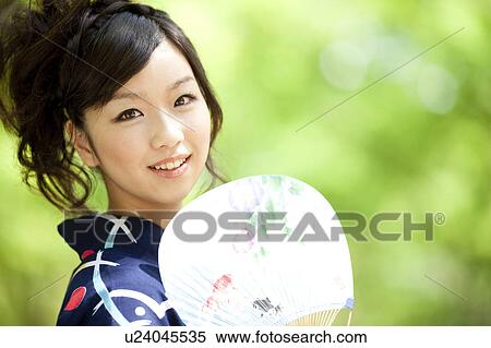 Stock Photography - Young woman wearing Yukata and looking at camera. Fotosearch