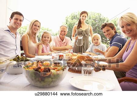 A family, with parents, children and grandparents, enjoy a picnic View Large Photo Image Picture - A family, with parents, children and grandparents, enjoy a picnic. Fotosearch