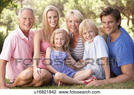 Stock Image - A family, with parents, children and grandparents, relaxing in a park. Fotosearch