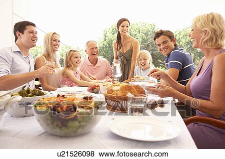 Stock Photo - A family, with parents, children and grandparents, enjoy a picnic. Fotosearch