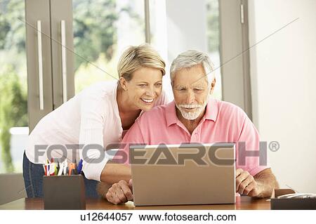 Adult Daughter And Senior Father Using Laptop At Home View Large Photo Image Stock Photo - Adult Daughter And Senior Father Using Laptop At Home. Fotosearch