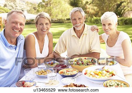 Adult Son And Daughter Enjoying Meal In Garden With Senior Parents View Large Photo Image Stock Photo - Adult Son And Daughter Enjoying Meal In Garden With Senior Parents. Fotosearch
