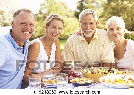Adult Son And Daughter Enjoying Meal In Garden With Senior Parents View Large Photo Image Stock Photo - Adult Son And Daughter Enjoying Meal In Garden With Senior Parents. Fotosearch