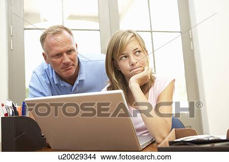 Angry Father And Teenage Daughter Using Laptop At Home View Large Photo Image Picture - Angry Father And Teenage Daughter Using Laptop At Home. Fotosearch