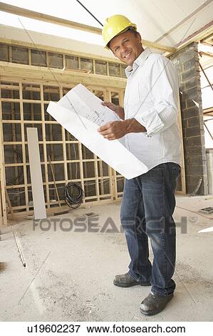 Stock Photo - Architect With Plans In New Home. Fotosearch