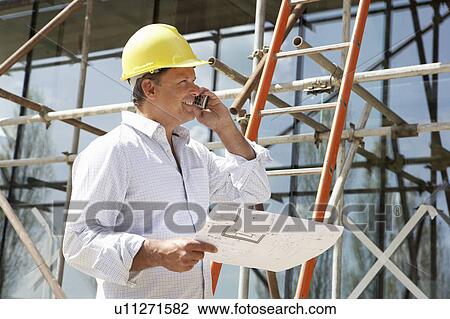 Architect With Plans Outside New Home Talking On Mobile Phone View Large Photo Image Stock Image - Architect With Plans Outside New Home Talking On Mobile Phone. Fotosearch