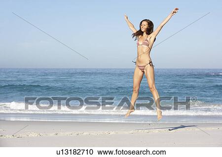 Athletic Young Woman Jumping On Sandy Beach On Holiday Wearing Bikini View Large Photo Image Stock Image - Athletic Young Woman Jumping On Sandy Beach On Holiday Wearing Bikini. Fotosearch