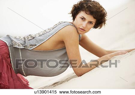 Stock Photography - Attractive Young Woman Wearing Revealing Clothing Standing Amongst Sand Dunes. Fotosearch