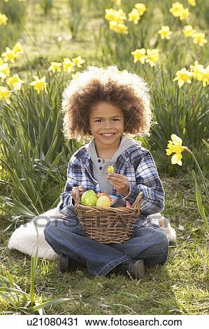 Stock Image - Boy On Easter Egg Hunt In Daffodil Field. Fotosearch