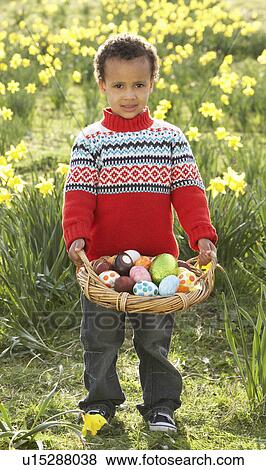 Stock Photo - Boy On Easter Egg Hunt In Daffodil Field. Fotosearch
