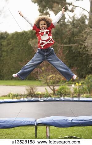 Stock Photo - Boy Playing On Trampoline. Fotosearch