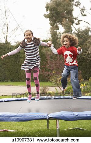 Stock Image - Children Playing On Trampoline. Fotosearch