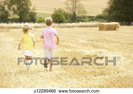Stock Photograph - Children Running Through Summer Harvested Field. Fotosearch