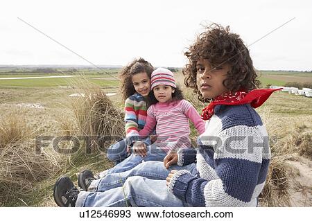 Children Sitting Amongst Dunes On Winter Beach View Large Photo Image Stock Image - Children Sitting Amongst Dunes On Winter Beach. Fotosearch