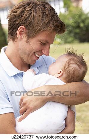 Close Up Of Father Cuddling Newborn Baby Boy Outdoors At Home View Large Photo Image Stock Photo - Close Up Of Father Cuddling Newborn Baby Boy Outdoors At Home. Fotosearch