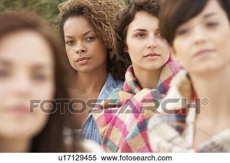 Stock Photography - Close Up Of Group Of Girls Sitting On Beach Together. Fotosearch