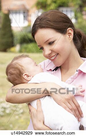 Stock Photo - Close Up Of Mother Cuddling Newborn Baby Boy Outdoors At Home. Fotosearch