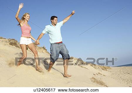 Couple Enjoying Beach Holiday Running Down Dune View Large Photo Image Stock Photo - Couple Enjoying Beach Holiday Running Down Dune. Fotosearch